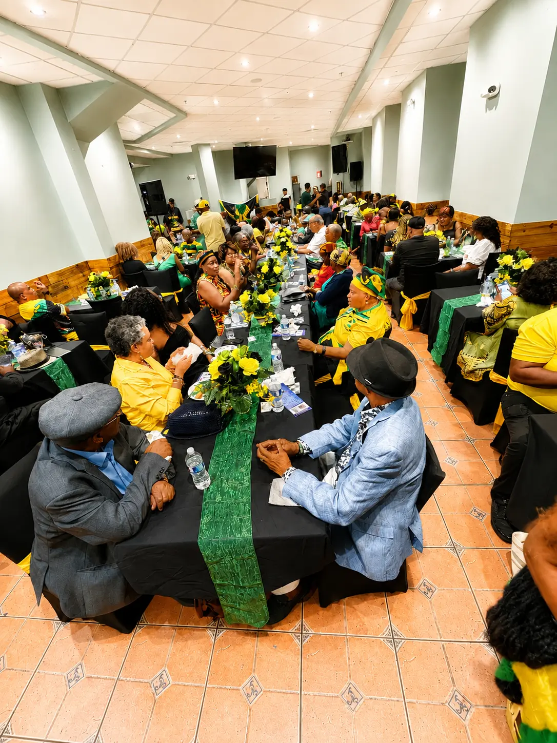 Guests seated at long banquet tables during a Jamaican celebration