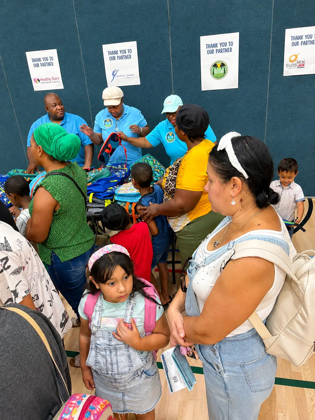 Families choosing backpacks at the back-to-school giveaway