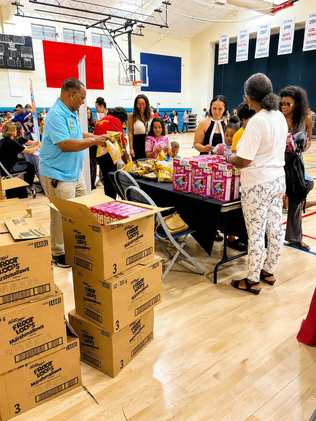 Volunteer handing out snacks and cereal boxes in the gym
